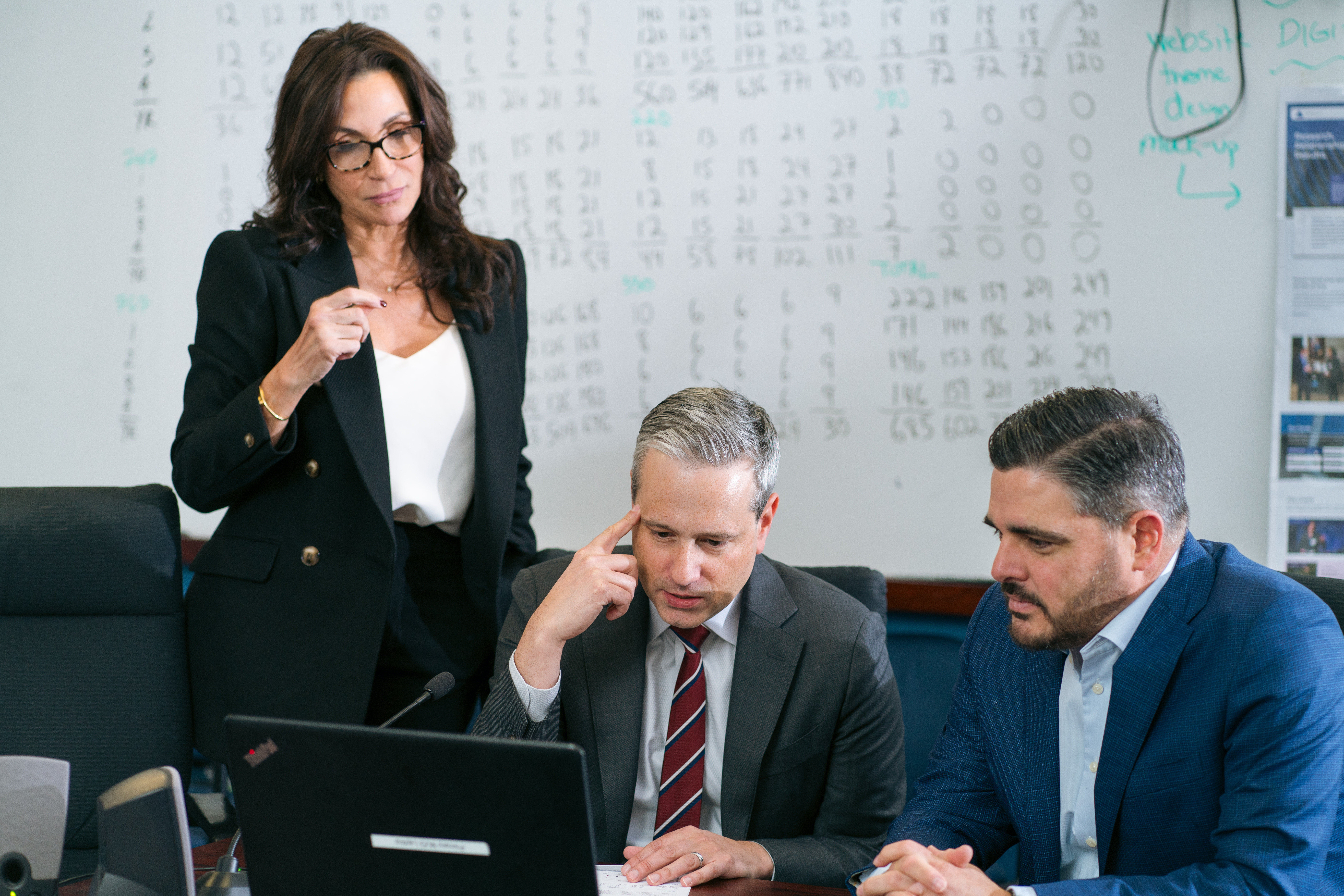 people at a table looking at a computer screen