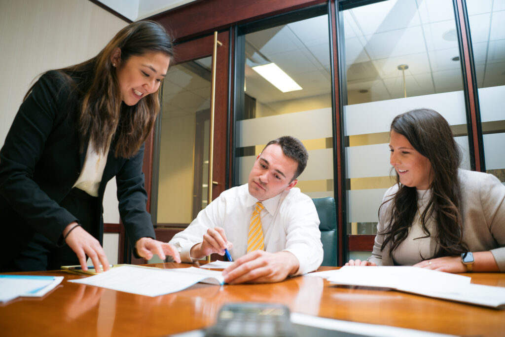 people working together smiling and looking at papers