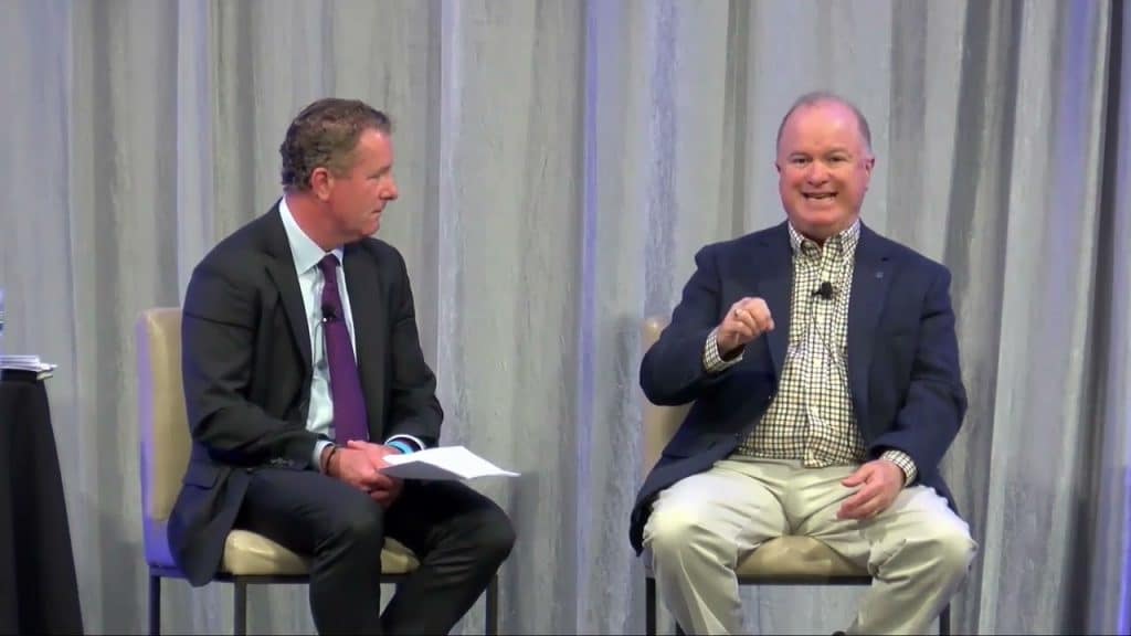 two people speaking on a stage