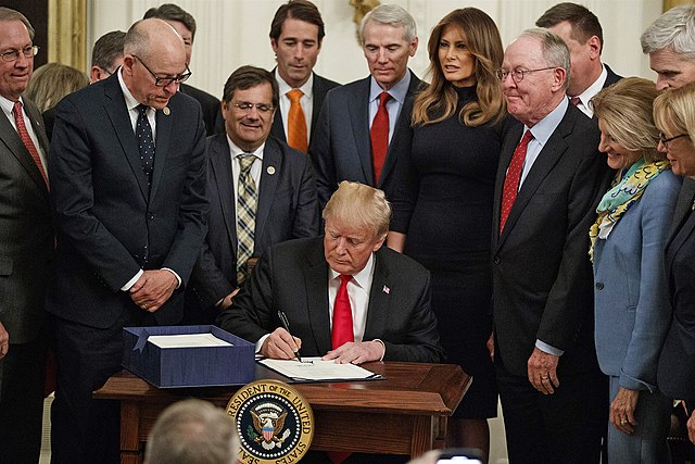 donald trump signing the support act around a bunch of people